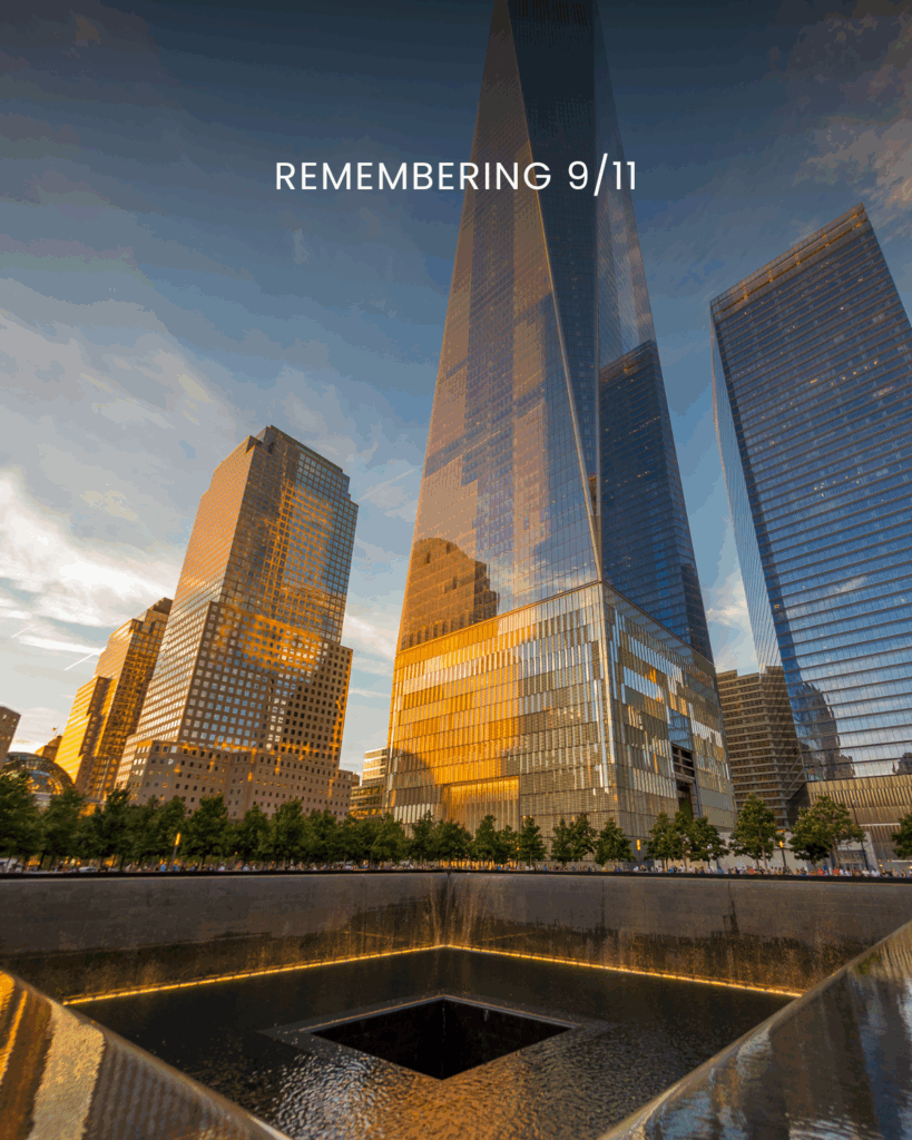 The 9/11 Memorial in New York City at sunset, with the reflecting pool in the foreground and tall glass skyscrapers, including One World Trade Center, glowing in golden light. The words "Remembering 9/11" appear at the top of the image.